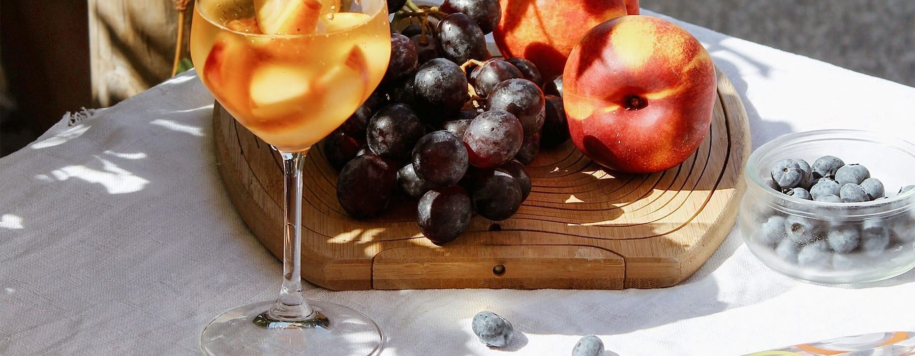 a board of fruit and a glass of wine